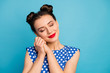 Closeup photo of pretty charming lady red pomade eyes closed hold hands near face overjoyed relaxed wear dotted white retro blouse shirt isolated blue color background