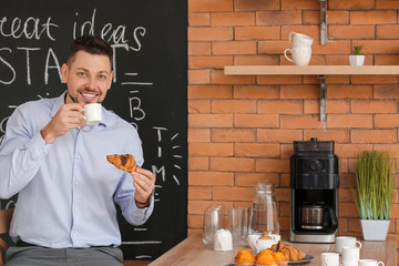 Wall Mural - Businessman drinking coffee in kitchen of office