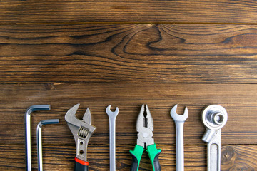 Set of tools over a wood panel with space for text. Top views with clear space