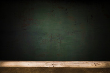 Poster - Old table top with brown concrete block wall in dark room background.