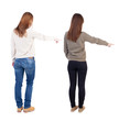 © ghoststone - Back view of two pointing girl in sweater.