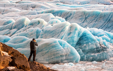 Wall Mural - Man photographs  the Svinafellsjokul glacier in southeast Iceland