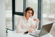 © Катя Іваськевич - young businesswoman working on laptop in the office. portrait of businesswoman. working in the office. happy business woman talking on the phone in the workplace. focused woman working.