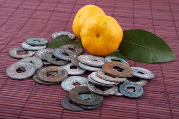 Canvas Print - Mandarin oranges and ancient Chinese coins on bamboo background. Symbols of luck and Chinese New Year.