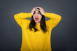 © Jihan - Horrible, stress, shock. Portrait of young emotional crazy woman clasping head in hands. Human emotions, facial expression concept. Trendy colors. Front view