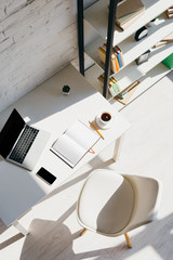 Wall Mural - top view of home office with laptop, smartphone and cup of coffee in sunlight