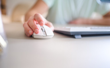 close up hand man using mouse and computer at home with morning light.