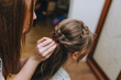 © shchus - Girl professional hairdresser braids the pigtail to the bride and makes a hairstyle close-up. Photography, concept.