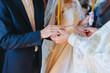 © shchus - The priest holds a wedding ceremony in the church, rites and puts gold rings on the fingers of the newlyweds. Photography, concept.