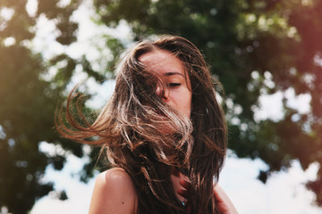 Cheerful girl portrait photo. Laughing girl close-up. Happy young girl. Beautiful girl with fluttering hair joyful. Summer joy, travel, tourism. Brunette with a smile on her face