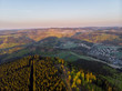 Luftaufnahme von den Wäldern des Sauerlandes bei Sonnenaufgang mit Winterberg im Hintergrund, Winterberg, Sauerland, Deutschland