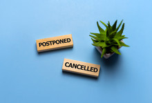 Postponed - Words From Wooden Block With Letters, Postponed Concept, Top View Blue Background
