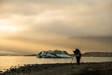 Fototapeta  - Photographer shooting icebergs in Jokulsarlon glacier lagoon during sunset time