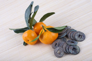 Canvas Print - Mandarin oranges and ancient Chinese coins on bamboo background. Symbols of luck and Chinese New Year.