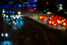 Defocused Image Of Illuminated Traffic Lights In City At Night