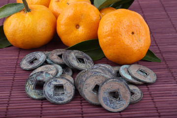 Canvas Print - Mandarin oranges and ancient Chinese coins on bamboo background. Symbols of luck and Chinese New Year.