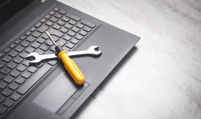 Wall Mural - Wrench and screwdriver on the computer keyboard. IT Service. Support