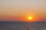 Fototapeta Zachód słońca - Evening sun in the sea with no cloudy skies.
