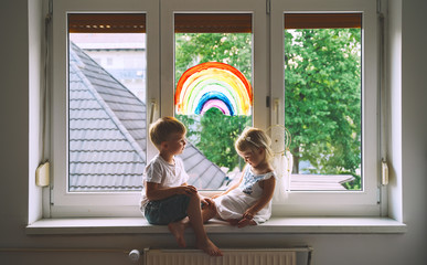 Wall Mural - Children on background of painting rainbow on window.