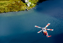 High Angle View Of Rescue Helicopter Flying Over Lake At Snowdonia National Park