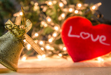 Bells And Heart Shape Against Illuminated Christmas Decorations