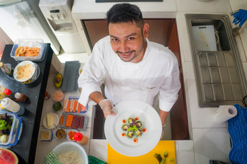 lifestyle portrait of Asian home cook man or professional chef cooking in clean kitchen showing traditional Japanese sushi roll dish happy and proud in Japan food culture