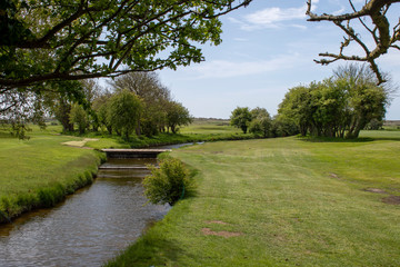 Wall Mural - Scenic view over the stream on a short par 3 at Littlehampton golf course.