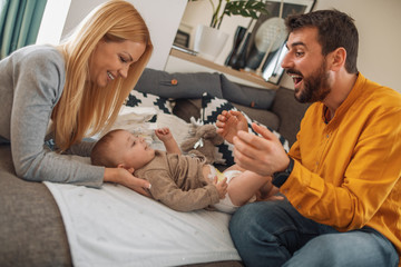 Wall Mural - Portrait of a young happy family with the baby at home