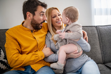 Wall Mural - Portrait of a young happy family with the baby at home