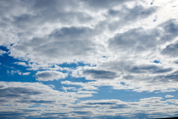 Light blue sky with white and grey clouds before the rain. Nature protection concept. Sunny day, warm weather.