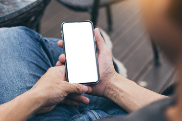 cell phone Mockup image blank white screen.man hand holding texting using mobile on desk at coffee shop.background empty space for advertise.work people contact marketing business,technology