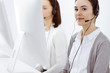 © Iryna - Call center. Casual dressed woman working in headset with diverse colleagues at office. Business concept