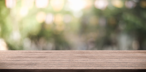 Wall Mural - Empty wooden table top and green nature blur background  for display product.