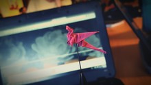 Close-up Of Red Dragon Origami Against Laptop