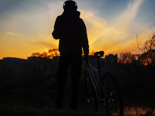 Wall Mural - Silhouette of a cyclist at sunset against the sky