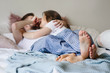 © elemakar - Newlyweds in pajamas are lying on the bed and hugging tenderly