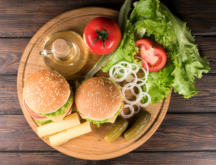 two hamburgers on a wooden background