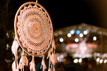 Handmade ethnic amulet, dream catcher against the background of the night city.