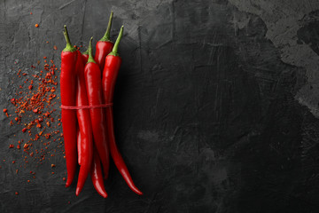 Wall Mural - Chilli peppers on black background, top view