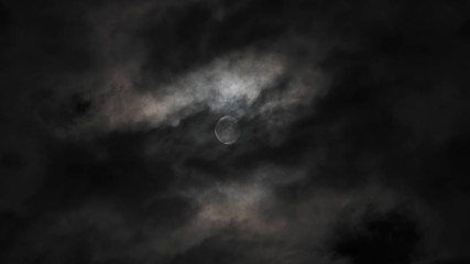 Wall Mural - moon behind dark clouds moving at night in real time