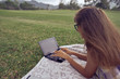© Ekaterina - Young woman using laptop computer on a park. Freelance work concept
