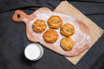 Food on a wooden board.
Baking, rolls, bread, bakery food. Milk in a glass.