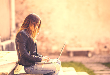 Young girl sitting on the stairs with a laptop.