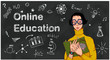© Anna - A student in glasses holds a book standing before chalkboard. Online education concept. Webinar, Tutorial podcast, Online training, School online learning.