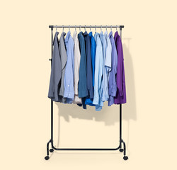 Wall Mural - Mobile rack with shirts isolated on light yellow background. File contains a path to isolation.