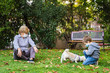 © progat - Grandmother and little kid playing with a smartphone in the backyard while wearing protective masks due to coronavirus outbreak