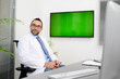 © W PRODUCTION - man male doctor professor teacher in medical office at desk with computer wearing white lab coat showing to students wall green srceen research covid19 and coronavirus seminar