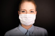 © Danny - Young European woman wearing face mask to protect from COVID-19 isolated on black background