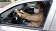 © aytug - Portrait of young woman driving a car wearing a hygienic mask to prevent airborne respiratory diseases such as infection, influenza and coronavirus (COVID-19).