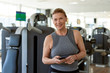 © Clique Images/Stocksy - Senior Woman With Smartphone In Gym Portrait